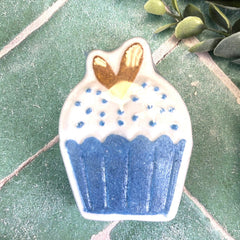 Cupcake-shaped decoration with blue base and white top on a green surface. Bath bombs in DuBois Pa.