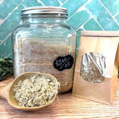 Blessed Thistle jar with a scoop of dried herbs on a wooden surface. Bulk herbal teas. Pennsylvania apothecary