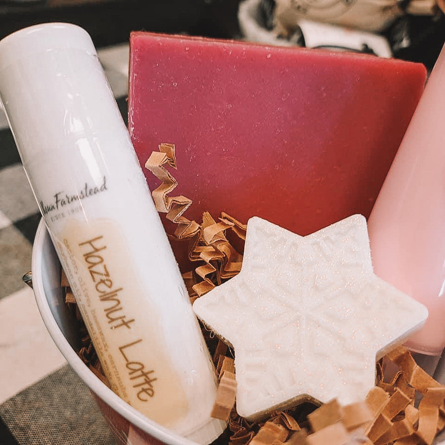 A close up image of gift set including a jumbo lip balm, goats milk soap bar, and snowflake soap.