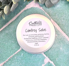 Comfrey salve container with label on a textured green surface