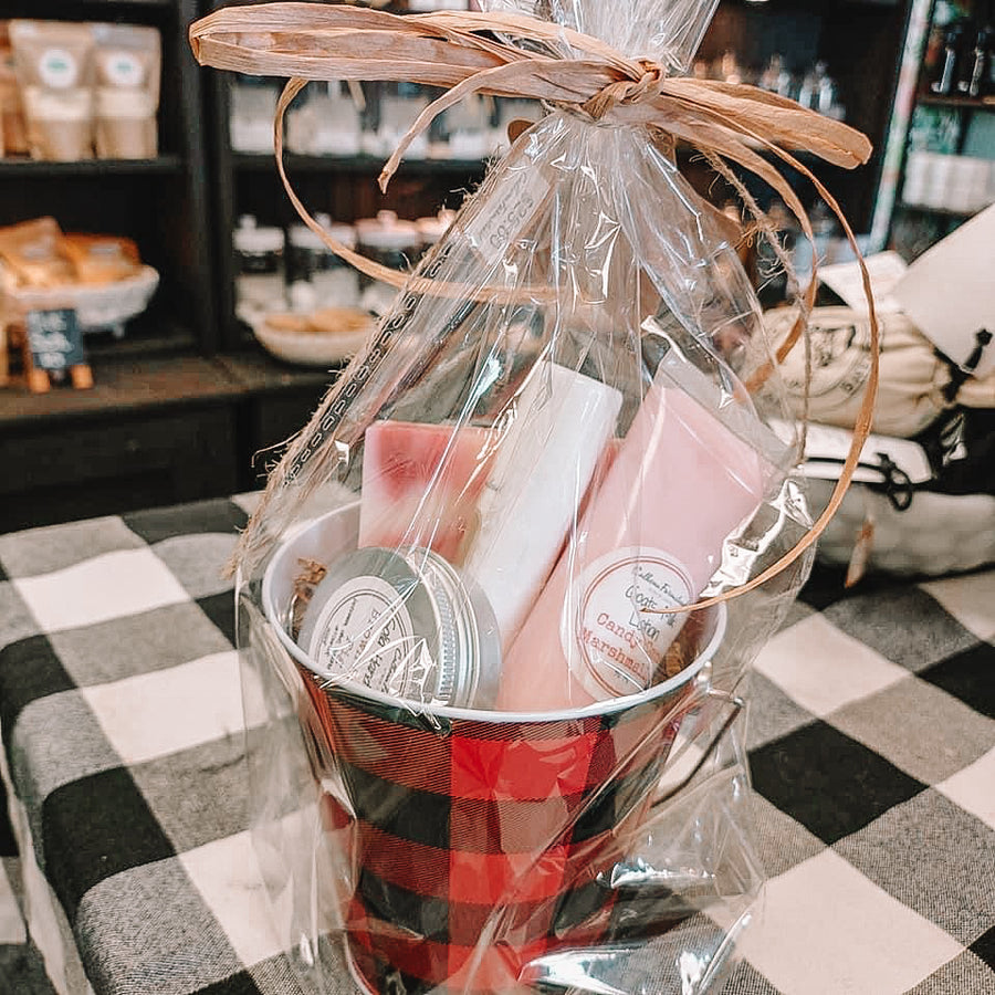 A gift basket packed in a tin milk pail. Filled with goats milk lotion tube, goats milk soap bar, jumbo lip balm and solid hand lotion tin.