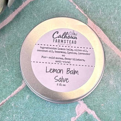Lemon Balm Salve container with label on a textured green surface