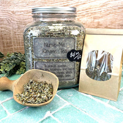 Glass jar of 'Nurse-Me Rhyme Tea' with a wooden scoop and packaging on a tiled surface. Herbs to improve lactation. Teas for moms.
