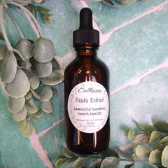 Bottle of Reishi Extract with a dropper on a green leafy background