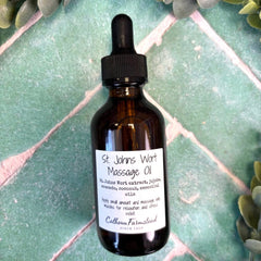 Bottle of St. John's Wort Massage Oil on a green tiled surface with greenery around.