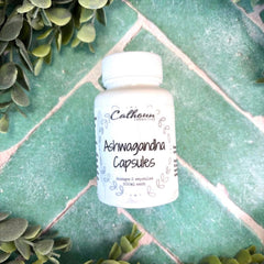 White bottle of Calhoun Ashwagandha Capsules on a green tiled surface with green leaves around. Herbal Supplements. Herb store in DuBois Pa