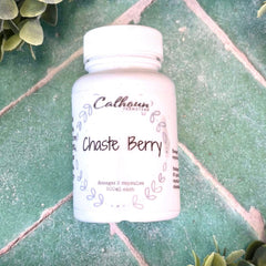 White supplement bottle labeled 'Chaste Berry' on a green tiled surface with greenery around. Herb store DuBois Pa. Herbal remedies.