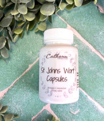 Bottle of St. John's Wort Capsules on a green tiled surface with greenery around.