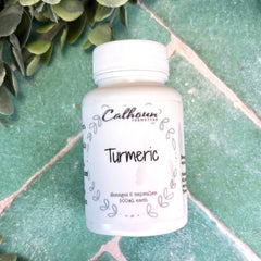 Bottle of Calhoun Naturals Turmeric capsules on a green surface with leaves. Apothecary near me.