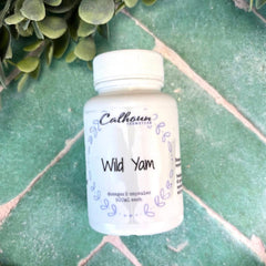 Bottle of Calhoun Wild Yam supplement on a green surface with Herbs for hormones.