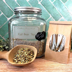 Glass jar of root beer tea with a wooden scoop and paper bag on a tiled background. Herbal teas for drinking. Natural root beer.
