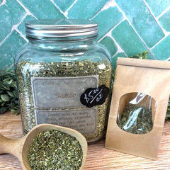 Herbal spice jar with a wooden spoon and packaging on a tiled background. Skullcap dried herbs. Herbs for anxiety. 