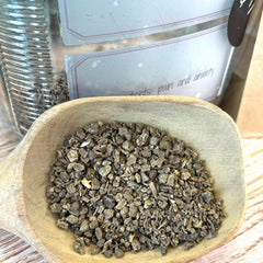 Wooden bowl filled with dried herbs on a wooden surface. Valerian root tea. Dried valerian herb. Apothecary.