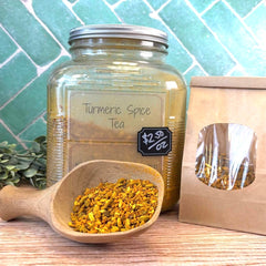 Turmeric Spice Tea jar with a scoop of tea and a paper bag on a tiled background. Benefits of Turmeric.