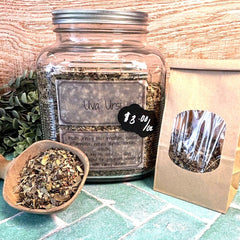 Glass jar with dried herbs, wooden spoon, and packaging on a wooden surface. Dried herbal Uva Ursi for urinary tract infections, bladder infections.