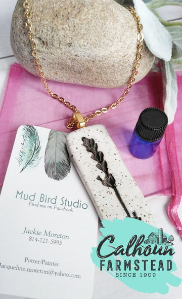 Aromatherapy essential oil necklace. Lavender. Clay medallion with raw clay imprint of unique lavender buds. Made by Mudbird Studio for Calhoun Farm. Comes with lavender essential oil. For relaxing and anti-anxiety.